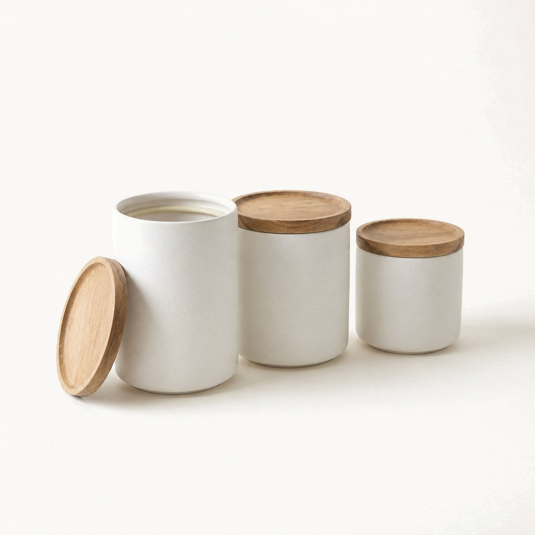 Ceramic canisters with one lid lifted off showing the opening