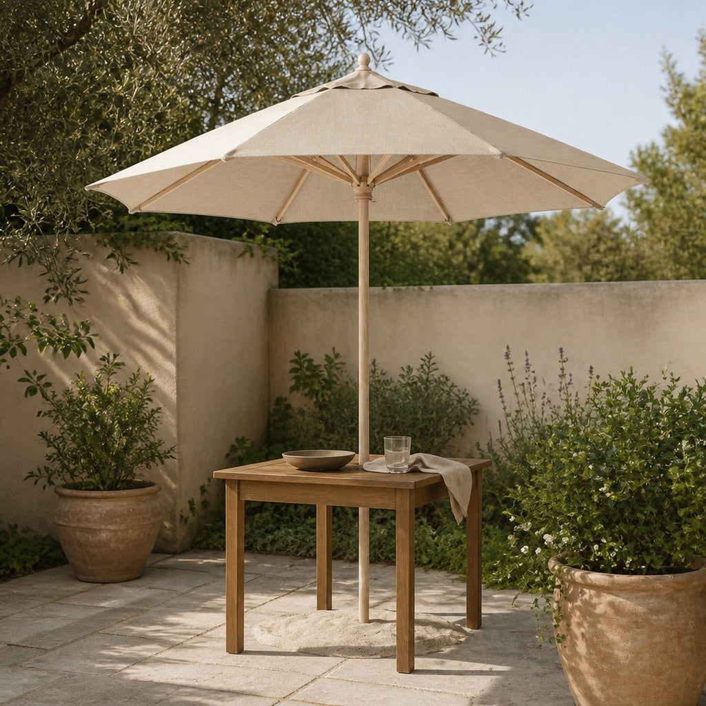 Canvas patio umbrella open over a table on a stone patio