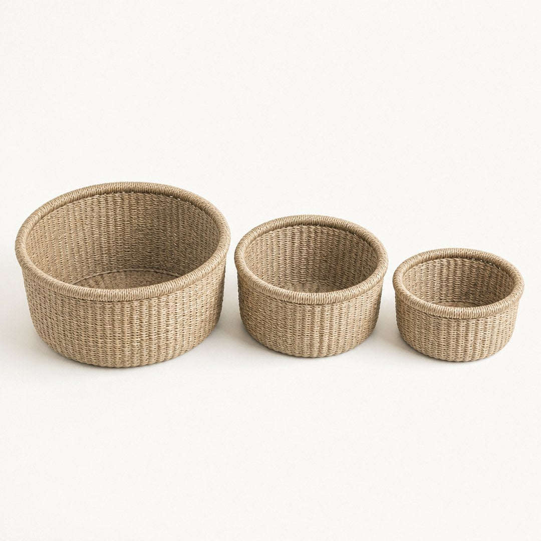 Three seagrass baskets side by side with one tipped open showing the lining