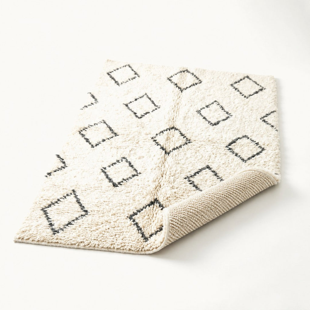 Berber shag rug with corner folded back showing pile depth and backing