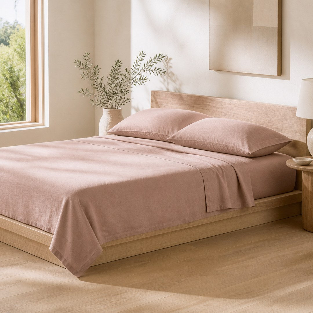 Cotton sheet set dressed on a made bed in an airy bedroom