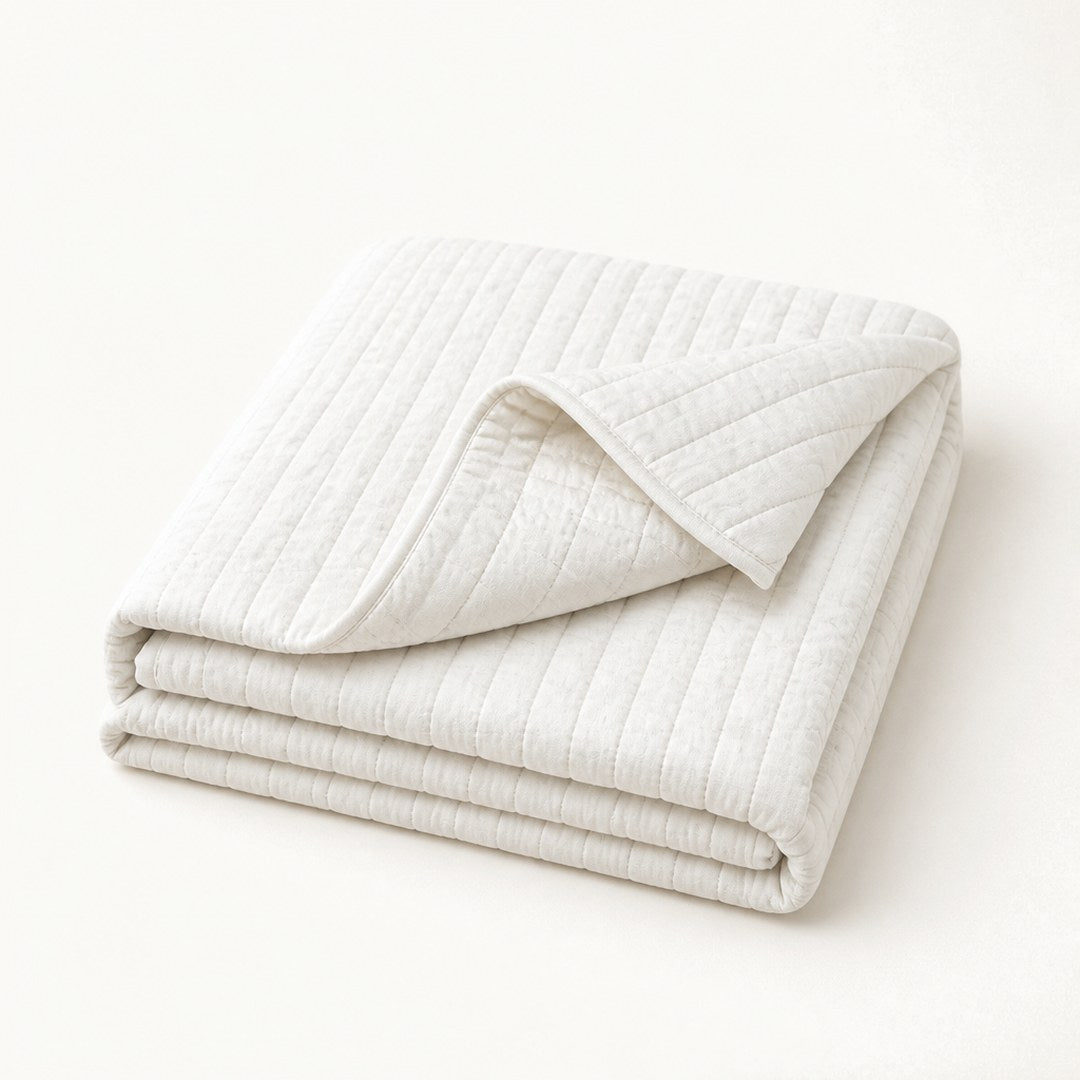 Quilted cotton bedspread with corner folded back showing quilting loft
