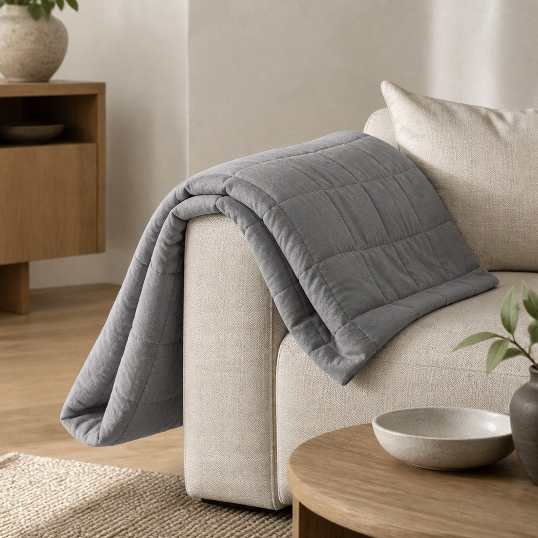 Weighted blanket draped over a linen sofa arm