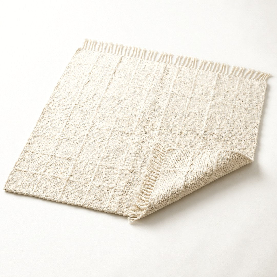 Hand-loomed wool rug with corner folded showing pile depth and weave