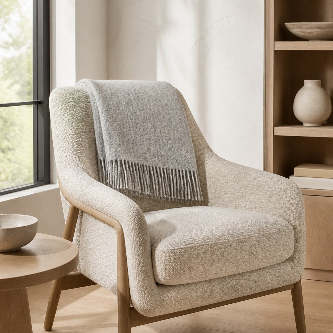 Lambswool throw draped over a reading chair by a window