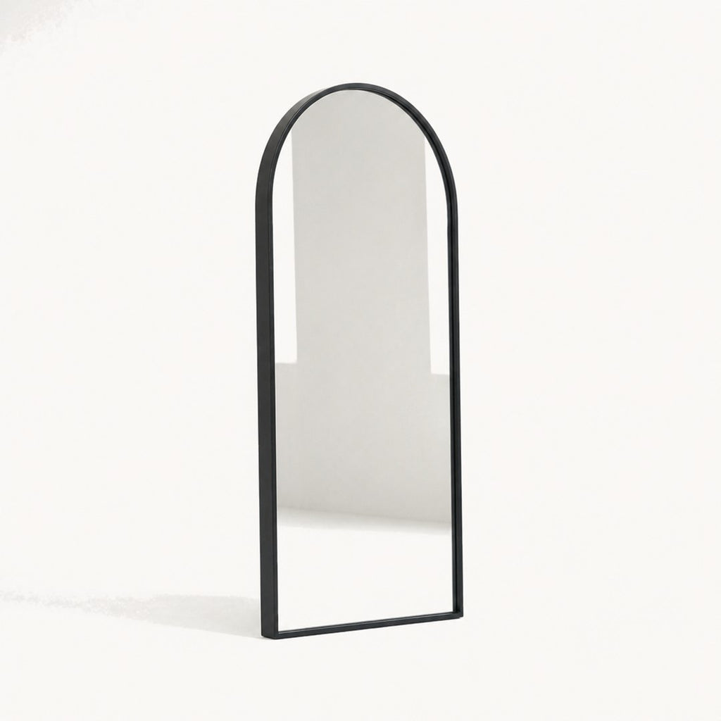 Arched wall mirror seen from a three-quarter angle showing the frame depth