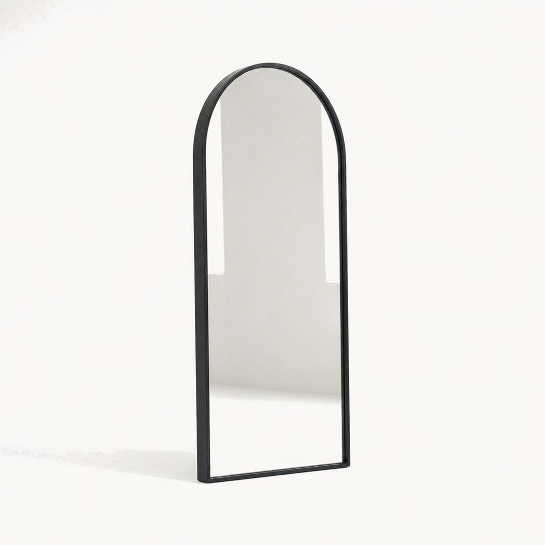 Arched wall mirror seen from a three-quarter angle showing the frame depth