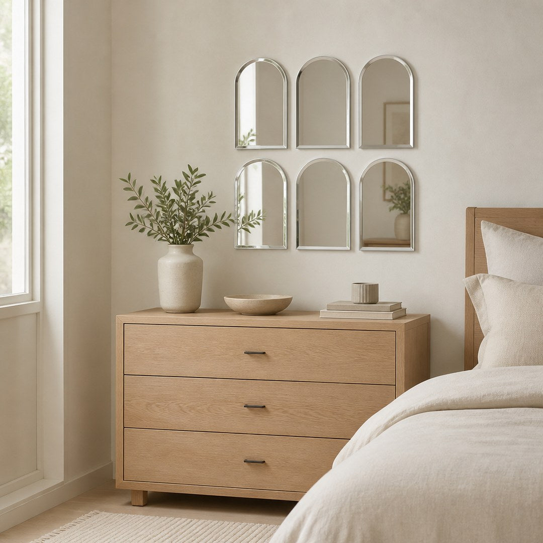 Arch mirror tiles arranged as a cluster above a bedroom dresser