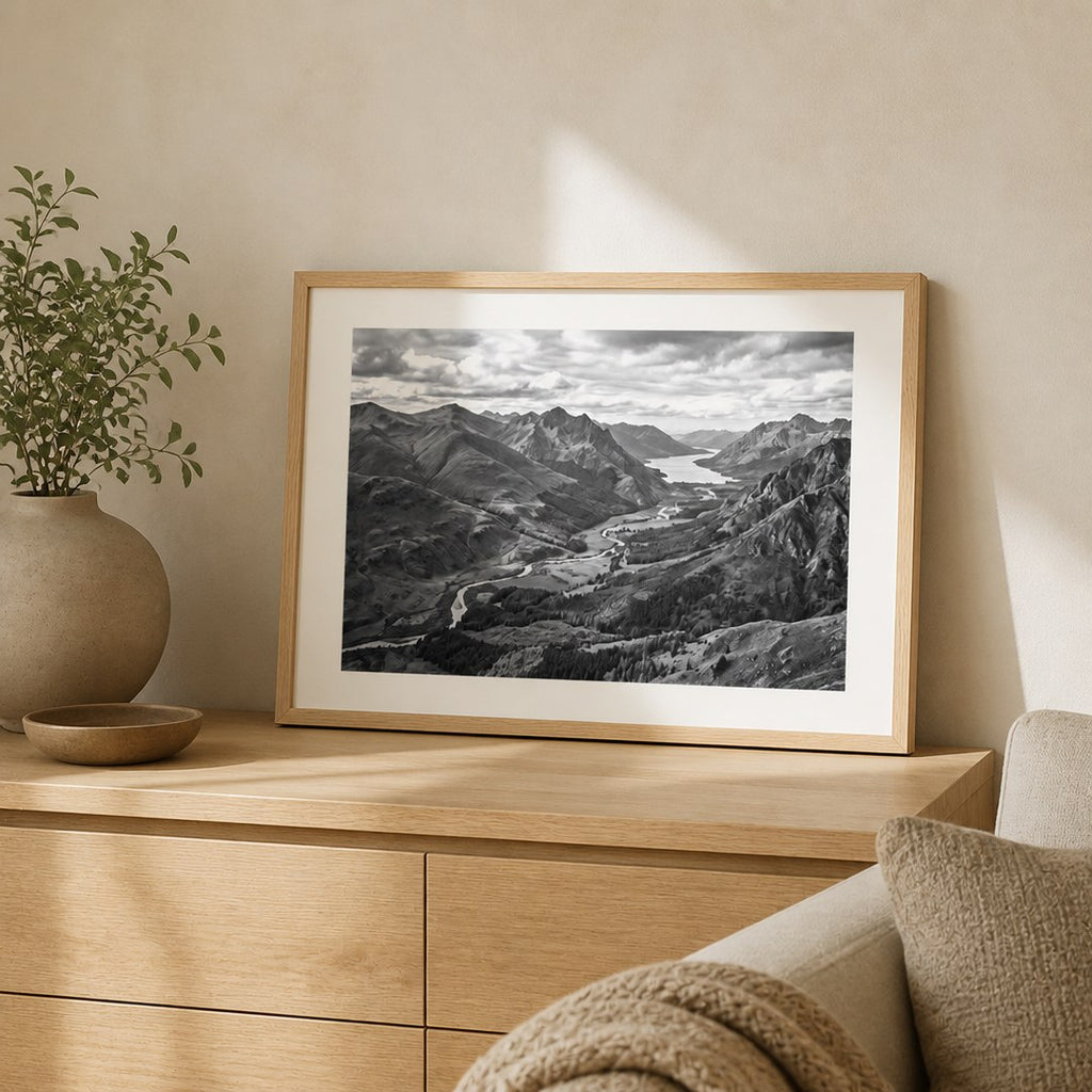 Framed landscape print leaning on an oak console in a living room